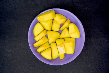 Mangoların üst görünümü siyah arkaplanda izole edilmiş bir tabakta dilimler