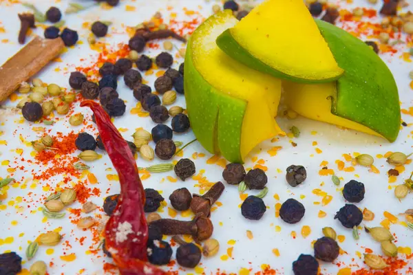 Stock image Very close-up and right side view of sprinkled indian spices for mango pickle like, red chilli, black pepper, clove, black cardamom, anise seeds etc. in white plate