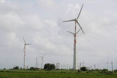 Bulutlu Gökyüzü Altındaki Enerji Alanında Rüzgar Türbinleri - Yenilenebilir Güç Kaynağı