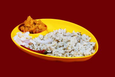 Left Side view of Gujarati Kathiyawadi Spicy Dhokali Sabji with khichdi, on yellow dish prominently, set against a black background clipart