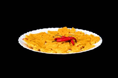 Gujarati Kathiyawadi Spicy Dhokali Sabji On White Plate, Red Chillies On The Top, Isolated On Black Background clipart