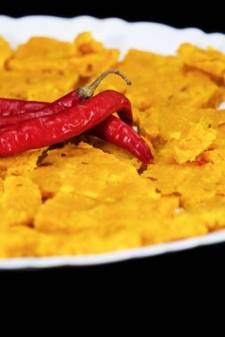 Portrait of Selective Focus Of Gujarati Kathiyawadi Spicy Dhokali Sabji On White Plate, Red Chillies On The Top, Isolated On Black Background clipart