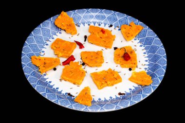 Gujarati Kathiyawadi Baharatlı Dhokali 'nin parçaları Sabji' nin siyah arka planda izole edilmiş yemeği vurguluyor.