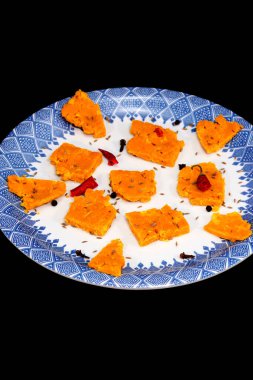 Gujarati Kathiyawadi Spicy Dhokali Pieces Sabji highlights the dish, alone against a dark backdrop clipart