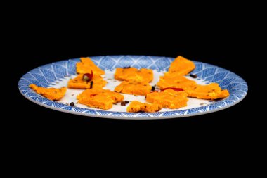 Gujarati Kathiyawadi 'nin yan görüntüsü Baharatlı Dhokali Parçalar Sabji' nin tek başına karanlık bir arkaplan karşısında altını çiziyor