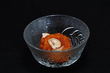 Two pieces of the traditional sweet treat Mohanthal, displayed in a glass bowl clipart