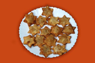 Domates soslu Aloo Puff Pastası. Kırmızı arka planı olan bir tabağa güzelce yerleştirilmiş..