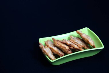 Yanında domates sosu ile servis edilen Aloo Puff Pastası 'nın üstünde kızarmış tavuk olan yeşil bir yemek..