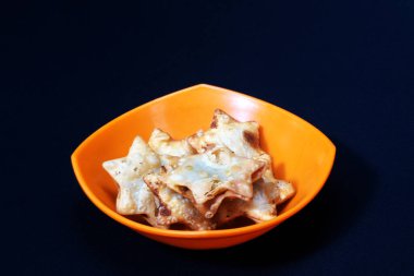 Yıldız şekliyle süslenmiş bir kase Aloo Puff Pastası, yanında da bir porsiyon domates sosu..