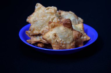 Mavi bir tabakta, daldırmak için domates sosu eşliğinde Aloo Puff Pastası yer alıyor..