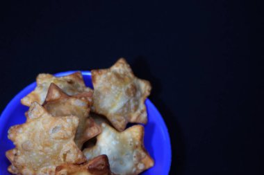 İçinde Aloo Puff Pastası olan mavi bir tabak yanında da domates sosu..