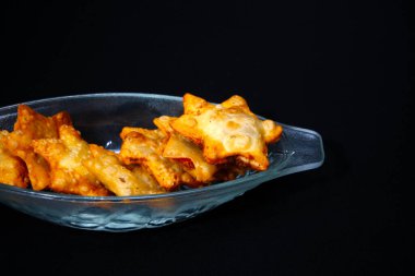 İçi kızarmış tavuk kanatlarıyla dolu cam bir kase. Güzel düzenlenmiş ve servis edilmeye hazır..