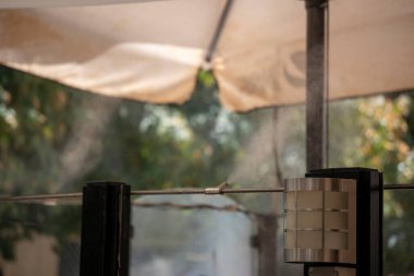 Granada, Granada, İspanya - 05 Ağustos 2023: Sıcak havayı azaltmak için nemlendirici ve soğutucu iklim yapmak için otomatik sis hortumu püskürtme sistemi. Sıcak yaz gününde su sisi makinesi çalışıyor.