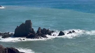 Sahildeki kayaların üzerinden geçen dalgaların yatay videosu. Yüksek kalite FullHD video