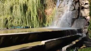 Şehir parkındaki çeşme. Su akıyor..