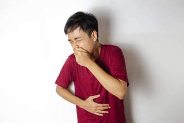 Öksüren ve karnını tutan bir ergen.