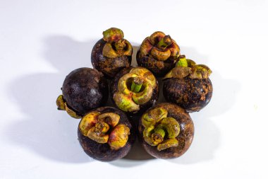 Beyaz arka planda düzgünce düzenlenmiş birkaç mangosen.