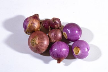 Sade beyaz arka planda servis edilen taze kırmızı soğanlar.