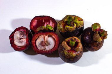 Beyaz arkaplanda, taze bembeyaz et ile düzgünce düzenlenmiş birkaç mangosen.