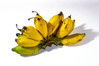 Beyaz bir arka planda servis edilen bir grup parlak sarı muz.