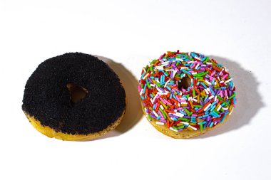 Çikolata tozu katılmış donutlar ve beyaz bir sırt çantasının üzerinde renkli serpintiler.