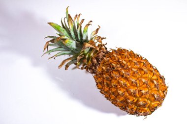 Ananas, beyaz bir arka planda yan çekilmiş.