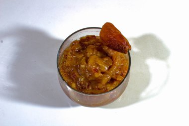 Hurma reçeli, mini cam bardaklarda servis edilir, üstünde hurma ile süslenir.