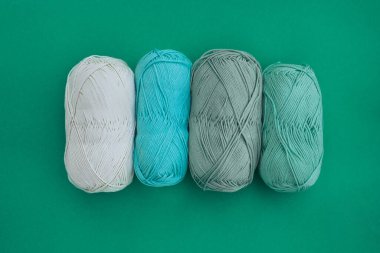 Dört sıra pamuklu kumaş, beyaz, açık mavi, zeytin ve açık yeşil arka planda. Örgü örmek, örgü örmek ve diğer el işleri için iplik..