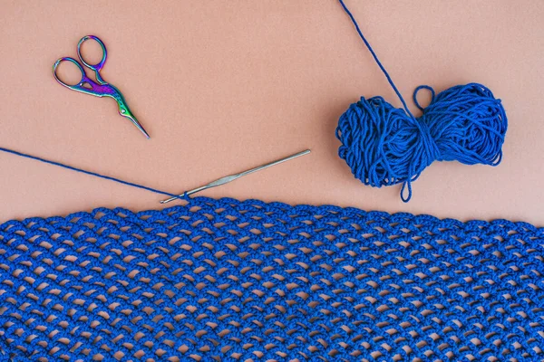 顶部的蓝色钩针网 蓝色的棉线 剪子和钩在环上 米色背景 简单裁剪的概念 — 图库照片