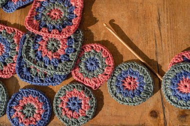Top view of crochet wooden hook and it's shadow in hard light amongs crochet samples with deep texture. Concept of making crochet patterns. clipart