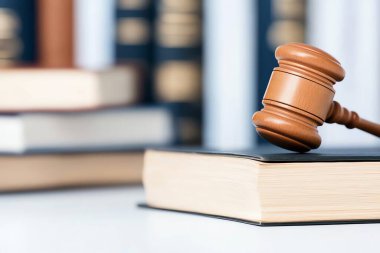 A close-up of a wooden gavel resting on an open law book. This image symbolizes justice, law, and the legal profession, perfect for articles and websites related to law and order. clipart