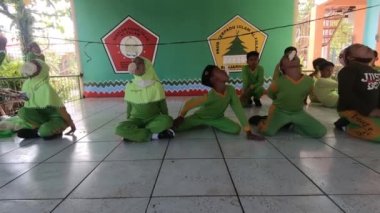 A child is currently eating crackers that are tied to a string. Muslim school children. Independence Day celebration. 4K video footage. South Kalimantan, Indonesia. August 18, 2022.