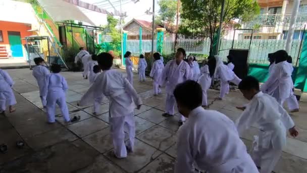Παιδιά Άσπρες Στολές Που Κάνουν Εξάσκηση Στην Πλάτη Καράτε Πολεμικών — Αρχείο Βίντεο