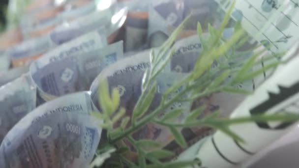 钱的花束印度尼西亚 南加里曼丹 印度尼西亚 紫色一万张印尼盾钞票 看起来像一朵绿色的花束 形成了独特而引人注目的图案 2023年11月27日 — 图库视频影像