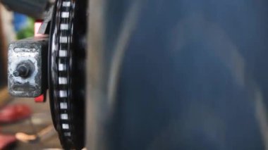 Dönen tekerlekle senkronize dönen bir motosiklet zincirinin görüntüsü. Bu yakın çekim koordineli hareket ve mekanik kesinlik, ulaşım ve mekanik ile ilgili projeler için idealdir