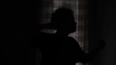 Saldırmak üzere olan bir adamın silueti öfke ve hayal kırıklığı gösteriyor. Gerginlik dolu bir an, yoğun bir duygu ve saldırganlık yakalıyor. Yumrukları, iç karışıklığı ve karanlık ışığı yansıtıyor. 4K 