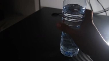 Siyah bir masanın üzerine temiz bir şişe maden suyu yerleştiriliyor. Kontrastta şişelerin berraklığı ve şekli vurgulanıyor. Ürün sergisi, su temaları, sağlıklı yaşam tarzı ve minimalist için ideal. 4k