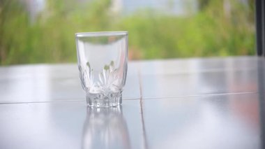 Doğal olarak bulanık arkaplanı olan temiz bir bardağa maden suyu dökmek. Temiz ve ferahlatıcı bir sahne. Susuzluk, sağlıklı yaşam ve temiz içme suyu temaları için mükemmel. 4K görüntüler. video
