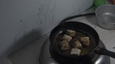 Sıcaklık artarken soya peyniri kaynayan yağda kızartılıyor. Yağ tofu parçalarının etrafında kaynamaya başlar, cızırtılı bir ses ve buhar yaratır. Tavada kızartılmış soya peynirinin yakın çekimi, 4K 'yı yakalıyor.