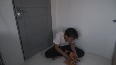 Giysileri yıpranmış zavallı bir adam olgun bir papayayı ikiye ayırıp tohumlarını çıkarıyor. Basit aletlerle yerde otururken, o dikkatlice meyveyi hazırlar. Sahne, günlük hayatta kalmayı ve alçakgönüllülüğü yansıtıyor.