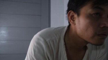 Yıpranmış gömlekli Asyalı bir adam elektrikli jilet kullanarak bıyığını tıraş etmeye hazırlanıyor. Aynanın karşısında duruyor, makası yüzüne yakın tutuyor, tımar etmeye hazır bir şekilde. Sessizlik. 4K