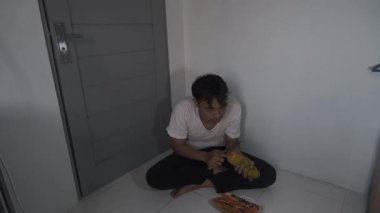 Dağınık bir adam yavaşça olgun papaya derisini soyuyor. Elleri ince dış katmanı dikkatlice kaldırıyor ve altındaki parlak turuncu eti ortaya çıkarıyor. Sahne çiğ ve basit bir yemeği yakalar. 4K