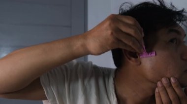 Fakir bir adam sağ ve sol yanaklarındaki favorileri tıraş ediyor. O, yıpranmış giysiler giyerek mütevazı durumuna rağmen özenle tımar etmeye odaklanır. Sahne, saf ve samimi bir anı yakalar. 