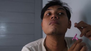 Dağınık bir adam, yanağındaki favoriyi ustura kullanarak dikkatlice tıraş ediyor. Onun dağınık görünüşü tımar etmeye gösterdiği ilgiyle çelişiyor. Sahne, ham ve gerçekçi bir görüntü yakalıyor. 4K