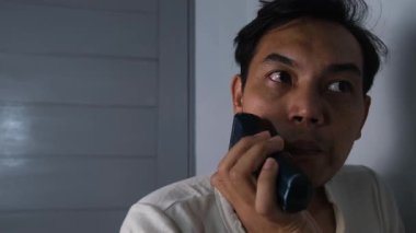 Dağınık bir adam bıyığını dikkatle temizliyor, yıpranmış ve haşin görünüşüne rağmen kişisel hijyene dikkat ediyor. O an, saf ve hakiki bir kişisel bakım eylemini yakalar. 4K