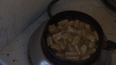 Kızartma tempeh süreci, parçalar kızgın yağlı sıcak bir tavada kahverengileşene kadar devam eder. Tempeh yavaş yavaş kızarır ve zengin renk ve doku gelişir. Bu yemek pişirme anı. 4K