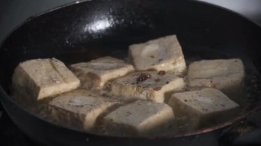 Kızarmış tofu kabarcıkları kızgın yağda yoğun bir şekilde köpükle ve kavurucu sıcakla çevrili ve çıtır çıtır altın bir dokuya dönüşüyor. Yağ reaksiyonu hareket ve doku yaratır ve canlı süreci yakalar. 4K