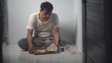 Asyalı bir adam yemeğini bitirdikten sonra su içer ve oradan ayrılır. Görüntüler günlük basit bir aktiviteyi, rutini, tatmini ve günlük hayatı yansıtıyor. Uygun. 4K