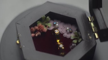 Altıgen şeklinde bir yüzük tutacağında bir çift altın alyans zarifçe dönüyor. Modern geometrik taban zarafet ve denge ekler, halkaların hareketi birliği ve bağlılığı sembolize eder. 4K