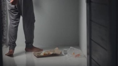 Asyalı bir adam bir porsiyon pirincin önünde yerde oturuyor, yemek için hazırlanıyor. An, basitliği, günlük rutinleri ve yemek yemenin temel eylemini yakalar. Bu sahne uygun. 4K 